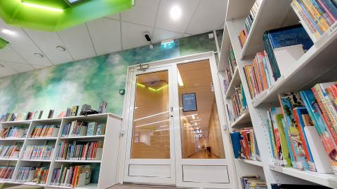 A black and white visitor counter above a glass door in the Koivistonkylä library.