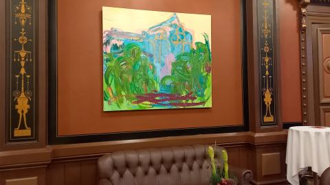 Ruskea vanha seinä, jolle on ripustettu abstrakti maalaus. 