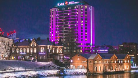 Hotelli Ilves kuvattuna iltaaikaan Hämeensillalta violetiksi valaistuna.