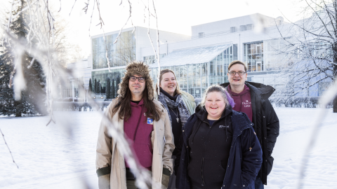 Four people look at the camera in Sorsapuisto in winter.