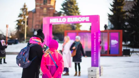 People look at their phones in front of UMK decorations in Sori Square.