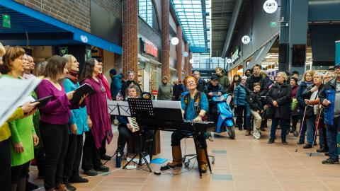 The choir performs in the lobby of the shopping center.