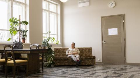Annamaija Saarela sits on a sofa in the hallway of the Nekala Cultural Center.