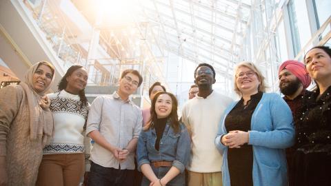 Eight Tampere residents from different cultural backgrounds stand side by side.