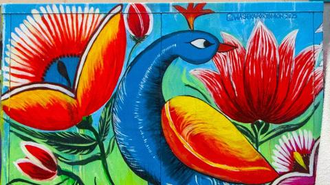 A painting of a peacock in shades of blue and red.