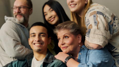 Five smiling people in a group photo.
