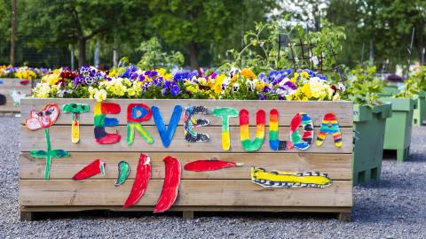 A gardening container with a colorful welcome message on the side.