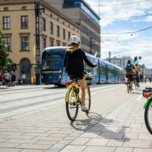 Cyclists on Hämeenkatu, a tram running in the background.