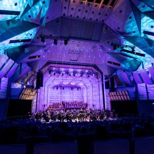 Tampere Filharmonia konsertoimassa Tampere-talon Isossa salissa. Salissa sinisävyinen valaistus.