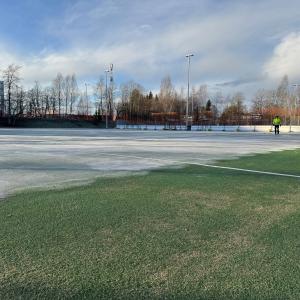 Kenttäalue, jossa osittain jäätä, osittain nurmea 