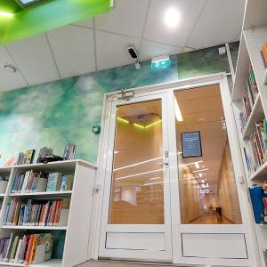 A black and white visitor counter above a glass door in the Koivistonkylä library.