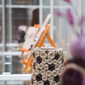 Pottery in a glass display case. In the middle is a pot, and on the side is a piece depicting a figure.