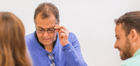 Ihmisiä pöydän äärellä. 