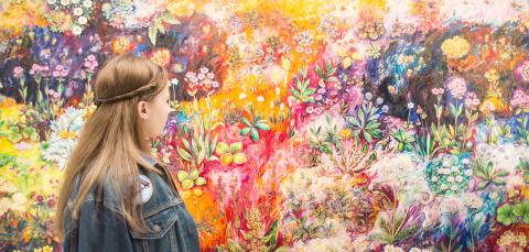 A person looking at a colourful painting.
