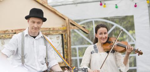 A guitarist and violinist playing for their audience.