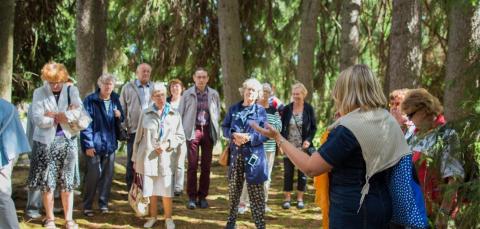 Guide speaking to a crowd of people in the woods.