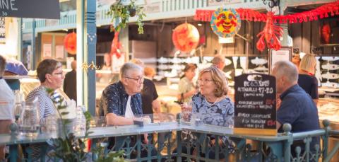 Two elderly couples at a table in the Kauppahalli.