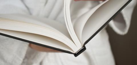 The person is holding an open book.