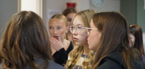Joukko oppilaita kuuntelevat ohjeita.