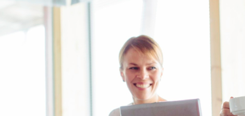 Three people happily discussing in a well-lit conference room.