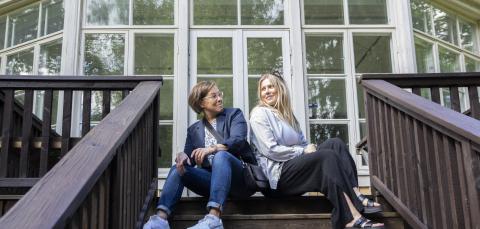 Kaksi naista istuu hymyillen Haiharan kartanon kuistilla.