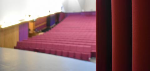 In the foreground is the stage curtain. In the background is the auditorium.