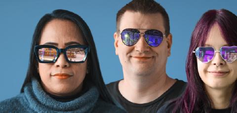 Four different people are looking ahead. They are all wearing sunglasses that reflect different views of the city.