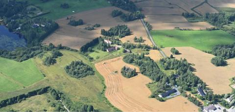 Ilmakuvassa näkyy peltoja, teitä, rakennuksia ja Näsijärvi.