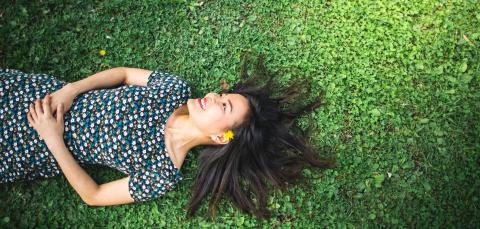 Tyttö makaa nurmikolla