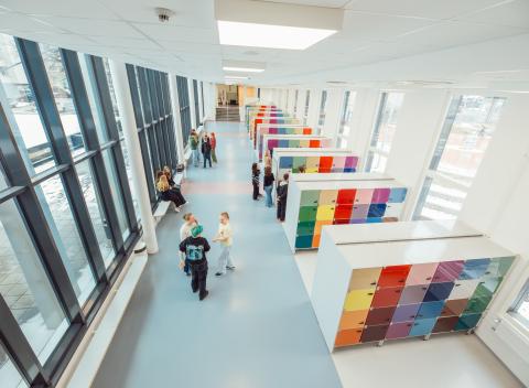 Lukiolaisia koulun käytävällä seisomassa.