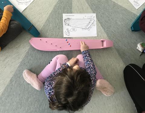 kuva tytöstä soittamassa kanteletta