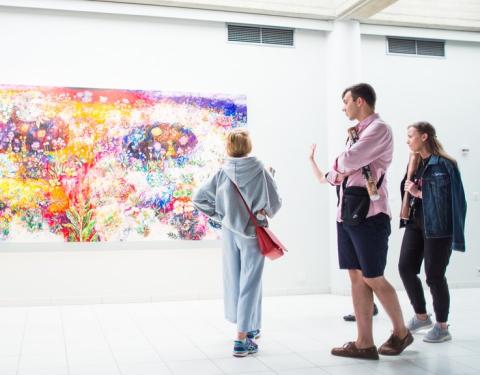 Ihmisiä taidenäyttelyssä. 