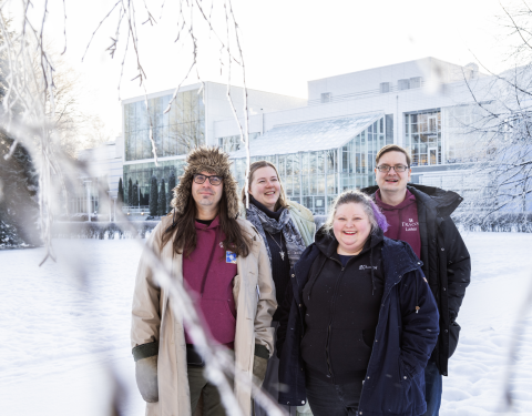 Four people look at the camera in Sorsapuisto in winter.