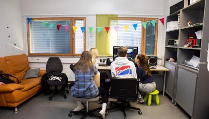 Opiskelijoita tietokoneen edessä.