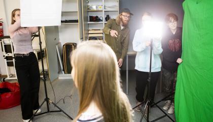 Opiskelijat järjestämässä kuvauksen valoja ja kankaita.
