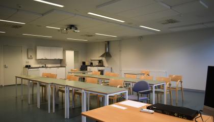 Classroom T23 in Sampola includes a lot of tables, chairs and a small kitchen.