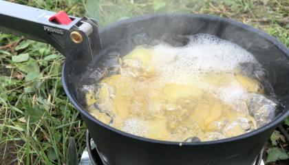 Perunat kiehuvat retkikeittimessä.