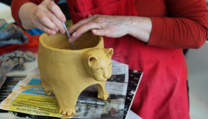 Henkilö tekee saviesinettä.