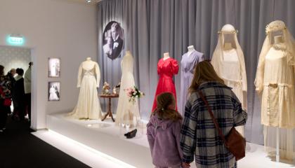 Kaksi henkilöä ihailemassa Museo Milavidan Kaunis morsian -näyttelyä.