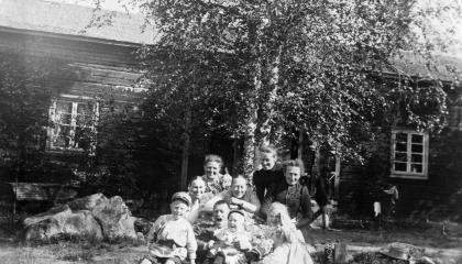 A group of Haihara guests and their children smile in front of the old building.