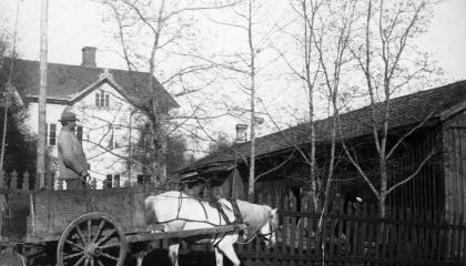 Man and horse-drawn carriages. Haihara Manor in the background, two storeys high.