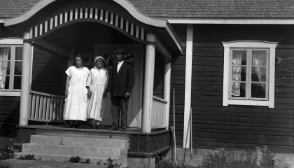 Three people are standing on the porch of Haihara's Väentuva.