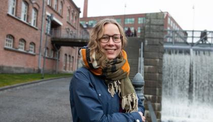 Olivia hymyilee kameralle Tammerkosken edessä.