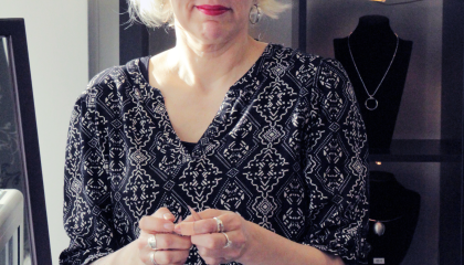 Henkilö pitelee koruja kädessään. Susanna Nurminen.