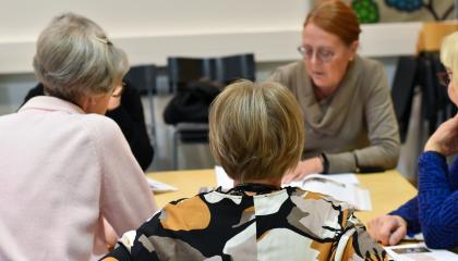 Henkilöt istuvat pöydän ääressä ja opiskelavat.