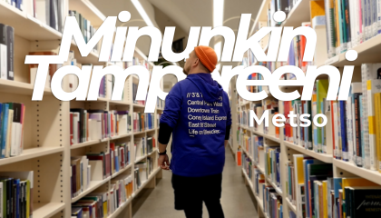 Mies katselee kirjoja kahden korkean kirjahyllyn välissä.