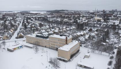 Nekalan vanha koulurakennus kuvattuna ilmasta talvisena päivänä.