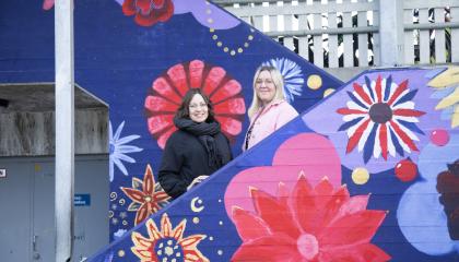 Hatanpään koulun Koivistontien koulutalon valmistavan luokan opettajat Mia Carita Hahl ja Elina Laukkala seisovat betoniportaikossa, joka on maalattu kukallisen värikkääksi.