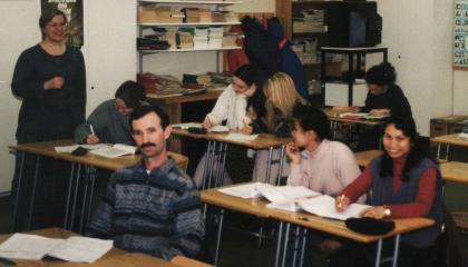 Henkilöt istuvat pulpeteissa kurssilla ja tekevät tehtäviä.