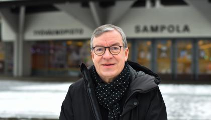 Henkilö seisoo Sampola-rakennuksen edessä.